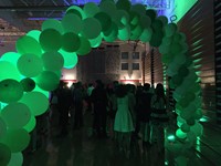 green arch welcoming students into homecoming dance