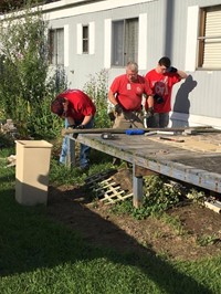 c v students and ramp it up coordinator continue work on removing old boards from deck.