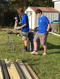 two students work on hammering nails in preparation for ramp it up project