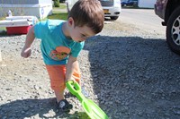 Little boy helps shovel at ramp it up project