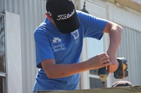 up close of student drilling nail into deck