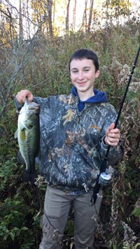 student holding a fish he caught