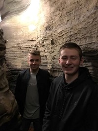 students smile for picture inside of rock structure