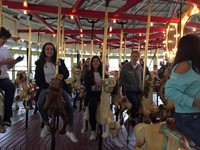 students smiling riding carousel