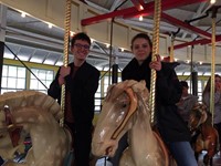 two students riding carousel