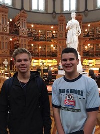 two male students smile inside library