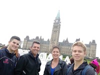 students and parents smile in front of building