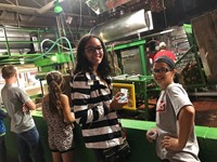 students watch apples getting pressed