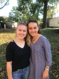 two female students smile in back yard