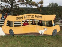 students pose in fake school bus at iron kettle pumpkin farm