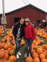 students at iron kettle pumpkin farm by pumpkins