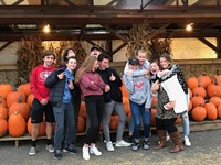 silly photo of group of students standing in front of pumpkins