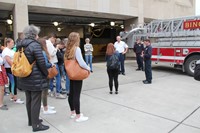 students talking with firemen and fire chief