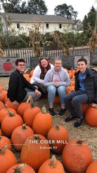students near pumpkins at cider mill