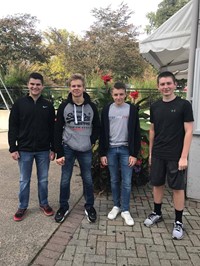 group of four male students outside