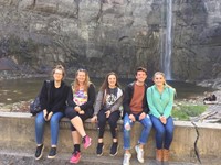 group of students sitting in front of water falls