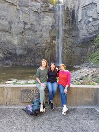 farther shot of teachers posing by water falls