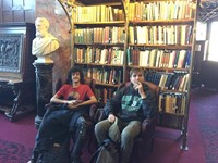 two male students pose in a library