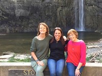 teachers pose for a picture in front of falls