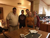 student and family smile in kitchen