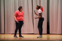 two female middle school students acting in play