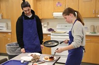 students pour final ingredients onto their grilled cheese sandwich