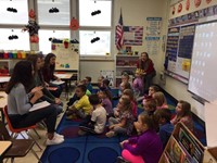 group of students talk to elementary students