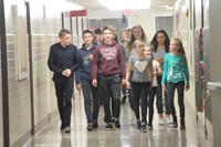 elementary students walking down hallway with french exchange students