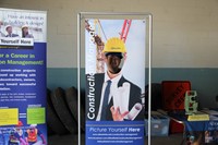 another student smiles inside of construction career day college poster