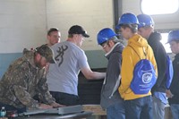 students talk with roofer inside at construction career day