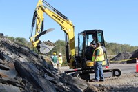 c v student uses claw machine to pick up rocks at construction career day