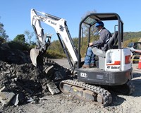 c v student using crane to pick up rocks at construction career day