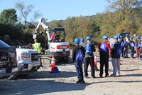 c v student lifts dirt using construction career day equipment.