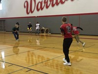 boys varsity football about to throw ball during passing challenge against a few teachers playing de