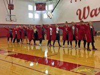 girls swim team does an enthusiatic dance during high school pep rally