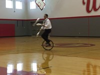mister stafford juggling while riding a unicycle