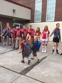 student athletes give students high fives as they enter port dickinson elementary