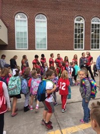 high school students give students at port dickinson elementary a warrior welcome greeting