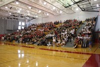 far shot of students in bleachers at high school pep rally