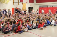 all elementary students wave small flags in the air