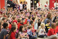 more students waving american flags in air