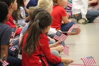 students holding small american flags