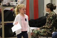 girl walks over to veterans holding thank you card