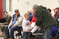 student handing veteran thank you card