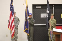 three color guard members holding flags