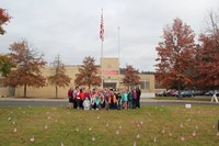 far shot of chenango bridge student council and c v staff with lawn full of flags