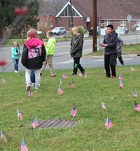 wide shot of students planting american flags in grass