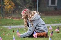 girl planting flag in grass outside chenango bridge elementary