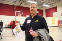 veteran smiling holding thank you card and flag