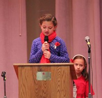 girl talking at podium at veterans day assembly